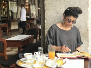 Artist Soula Mantalvanos sketching at a cafe