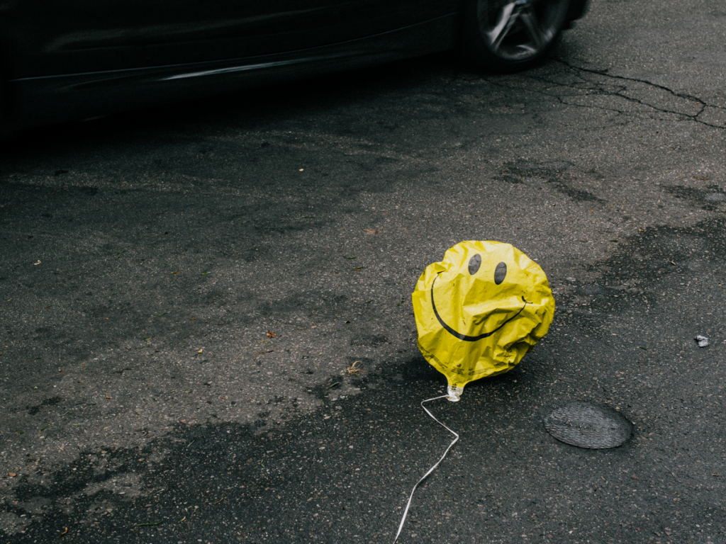 Deflated happy face balloon shows it's hard to stay happy when you have chronic pain.